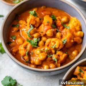 A bowl filled with cauliflower, chickpeas, and broth