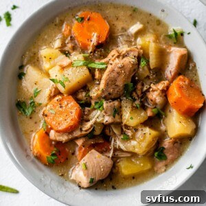 a bowl of stew with chicken, potatoes and carrots