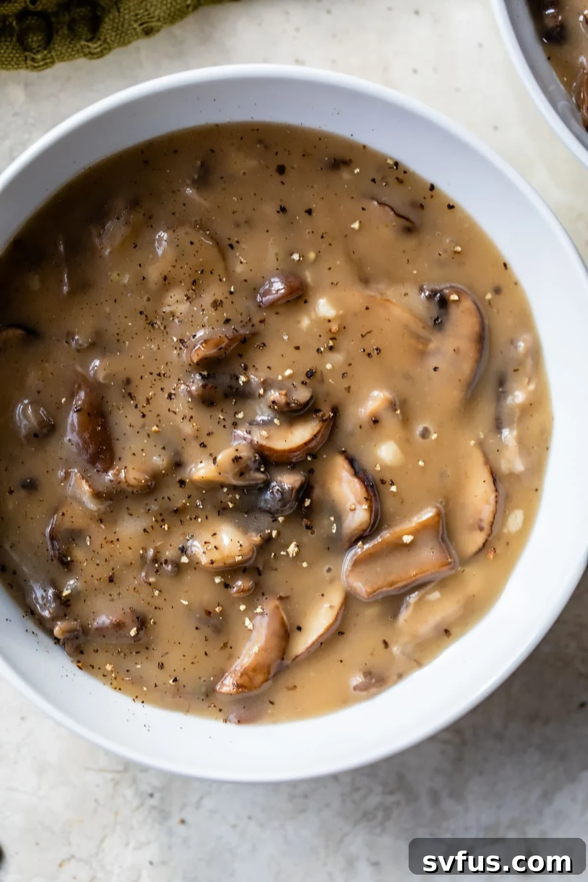A beautifully presented bowl of creamy vegan mushroom soup, garnished and ready to enjoy.