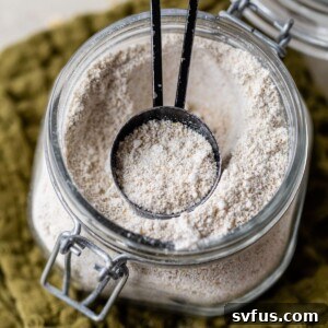 a glass jar with oat flour and a tablespoon measuring spoon in it