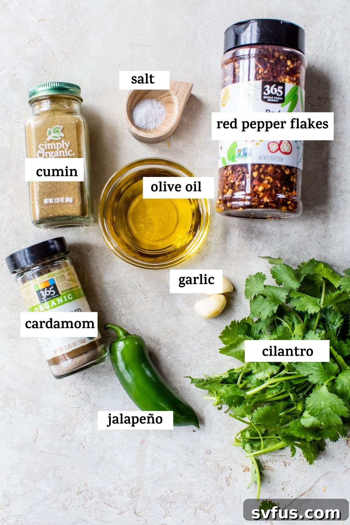 A neatly arranged collection of fresh ingredients laid out on a wooden board, ready to be transformed into Zhoug sauce, with text overlay.