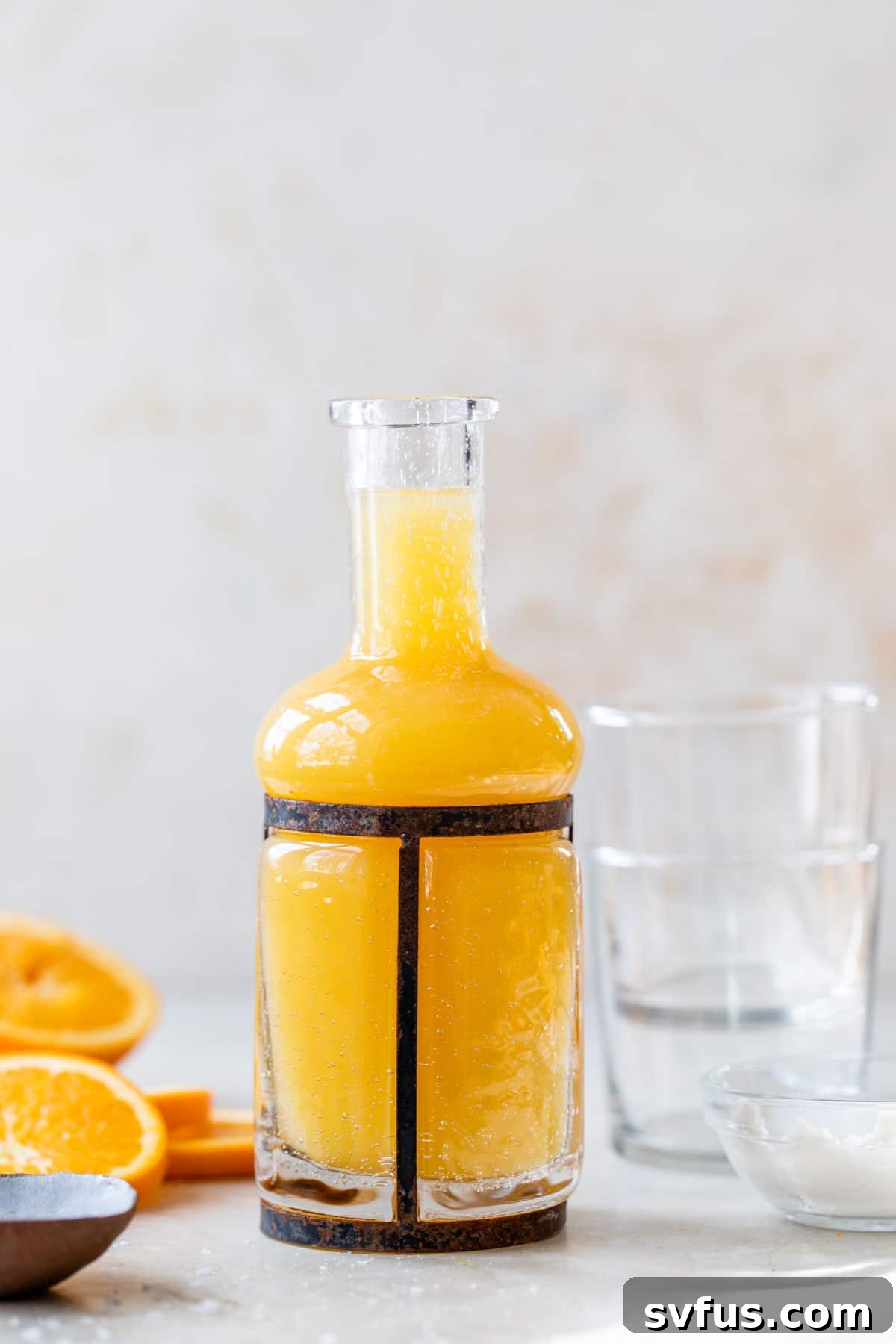 a tall glass jar filled with orange juice