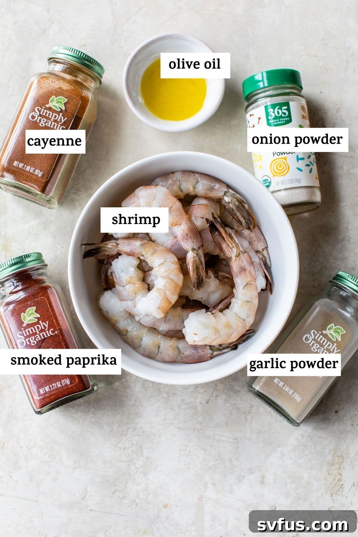Key ingredients for air fryer shrimp including raw shrimp, olive oil, and a selection of spices like paprika and garlic powder.