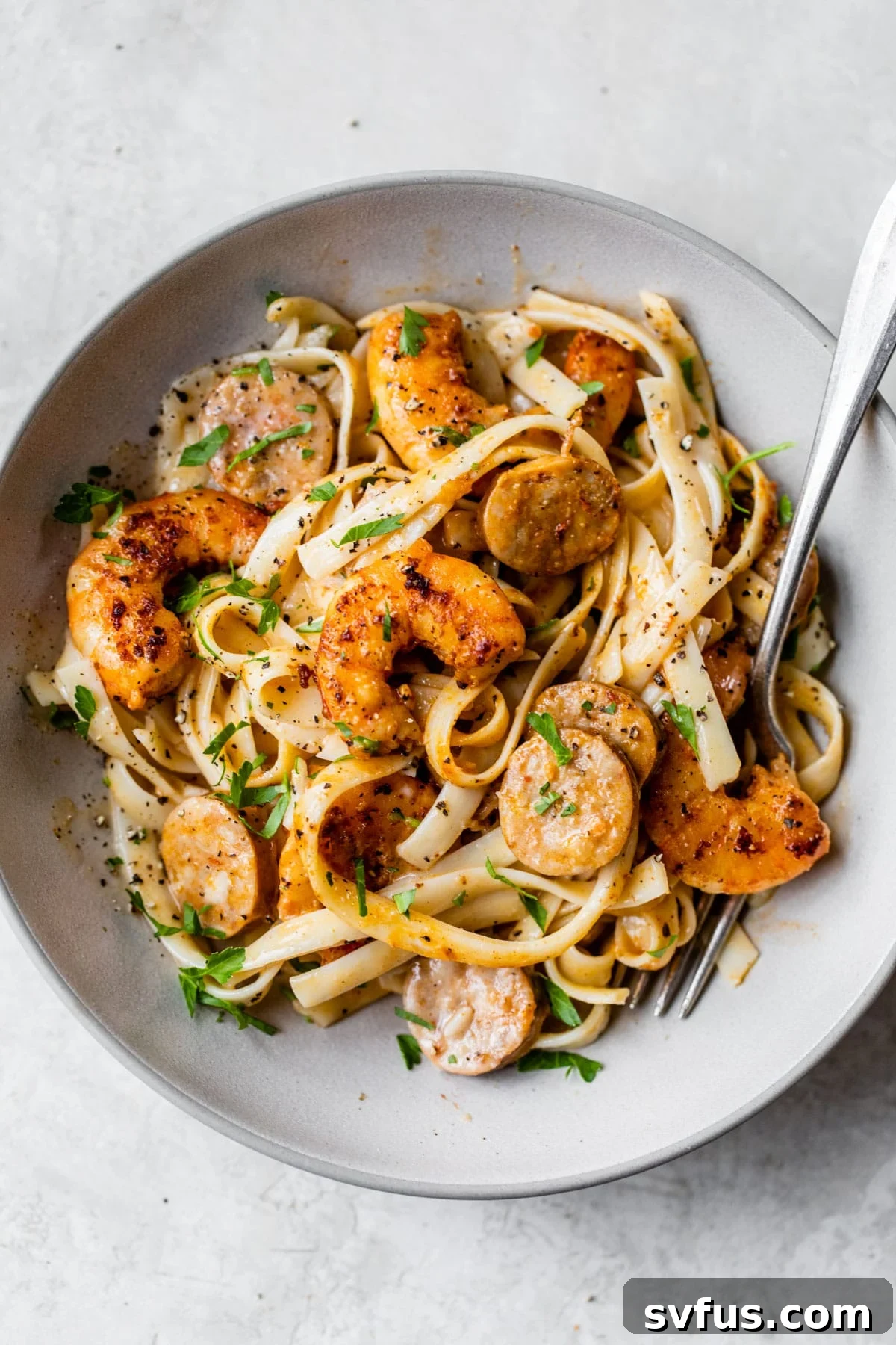 A beautifully plated bowl of Cajun Shrimp Alfredo garnished with fresh parsley.