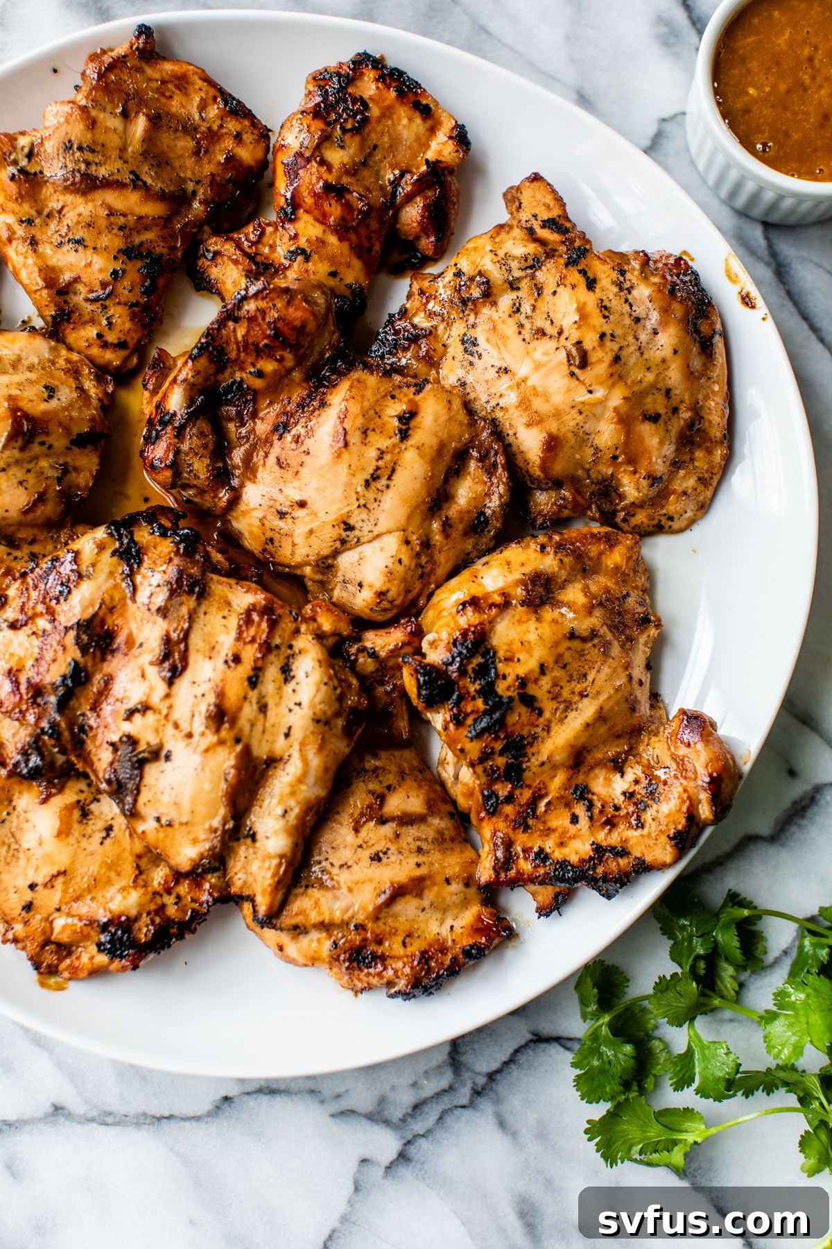 Golden-brown grilled chicken thighs arranged neatly on a platter, ready to be served.
