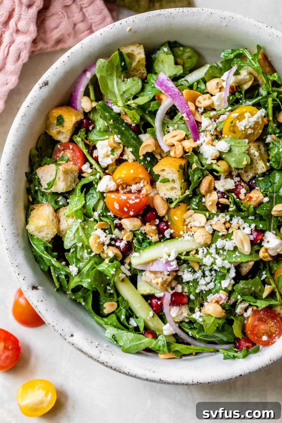 Large, vibrant Fattoush salad in a decorative bowl with mixed greens, crispy croutons, tomatoes, cucumber, and various garnishes.