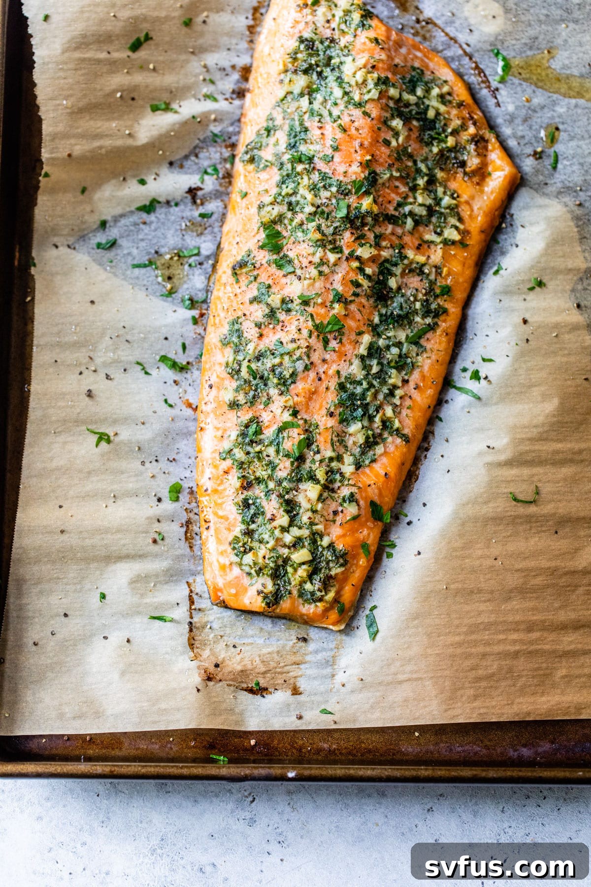 baked salmon fillet on parchment paper on a baking sheet, ready to be served