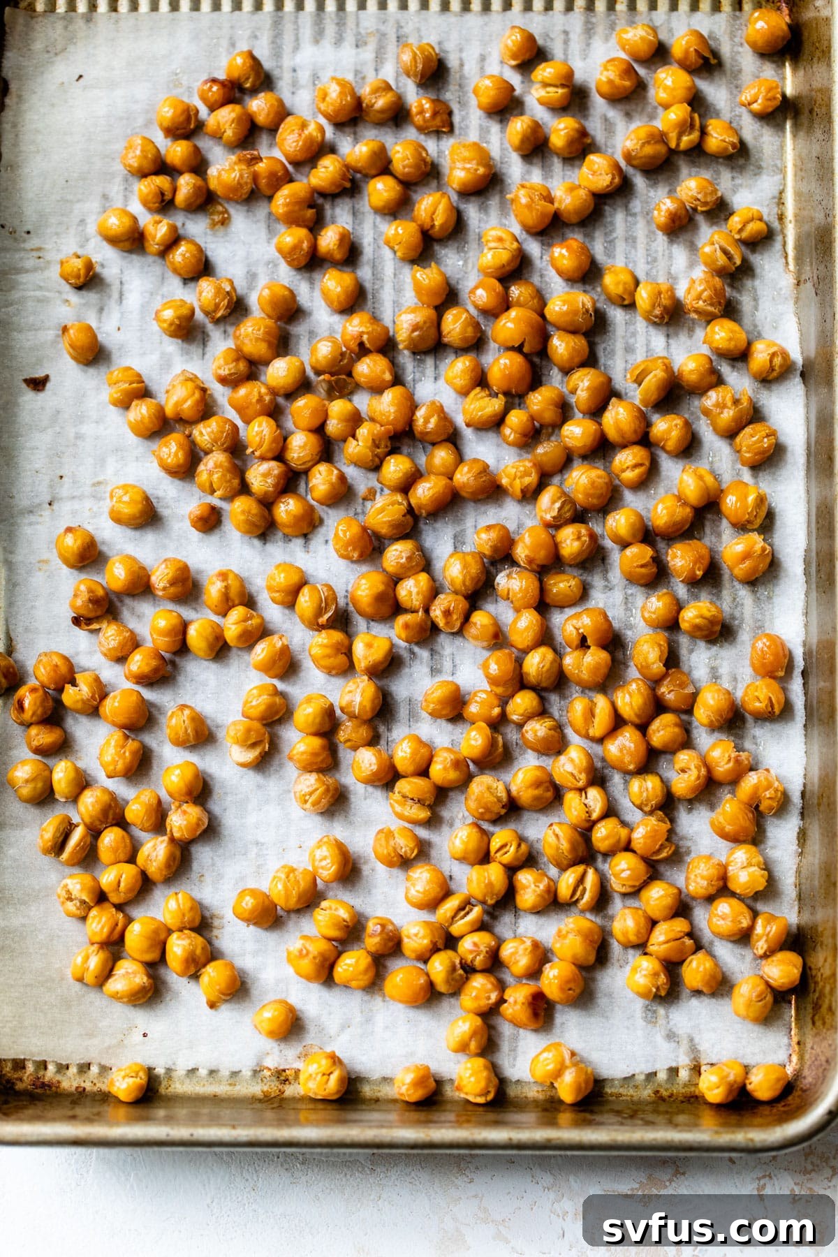 roasted chickpeas spread out on a baking sheet, golden and crispy