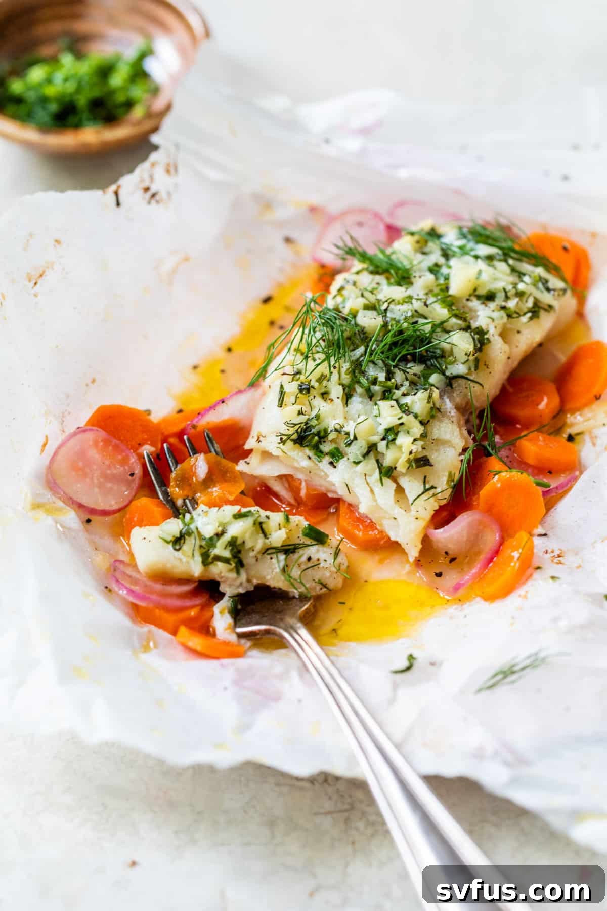 white fish in parchment pouch with butter and herbs