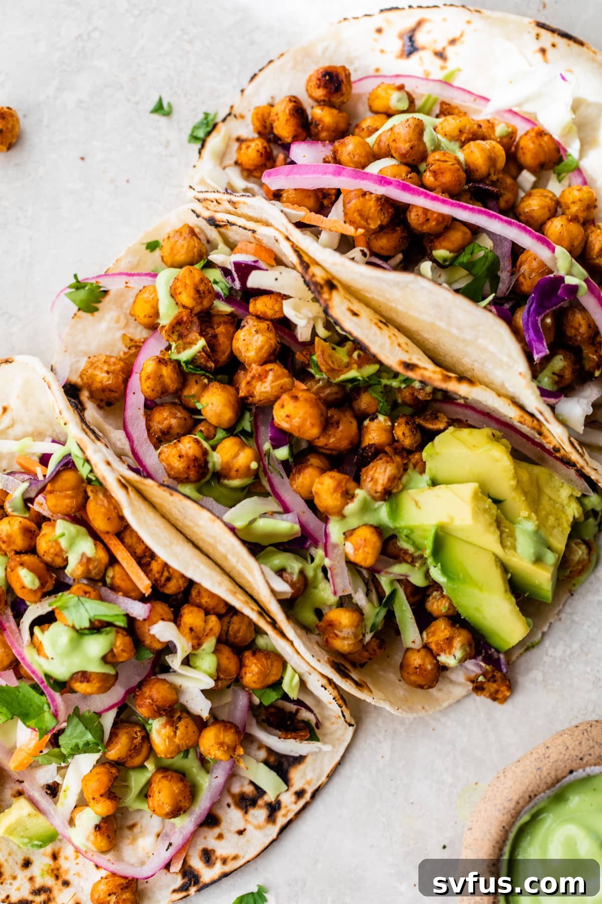 Three perfectly arranged chickpea tacos, showcasing their colorful and inviting fillings, ready to be enjoyed.