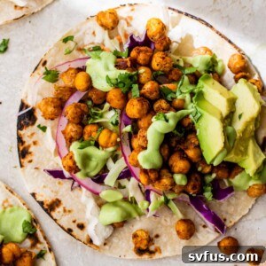 taco shell topped with chickpeas, red onion and avocado