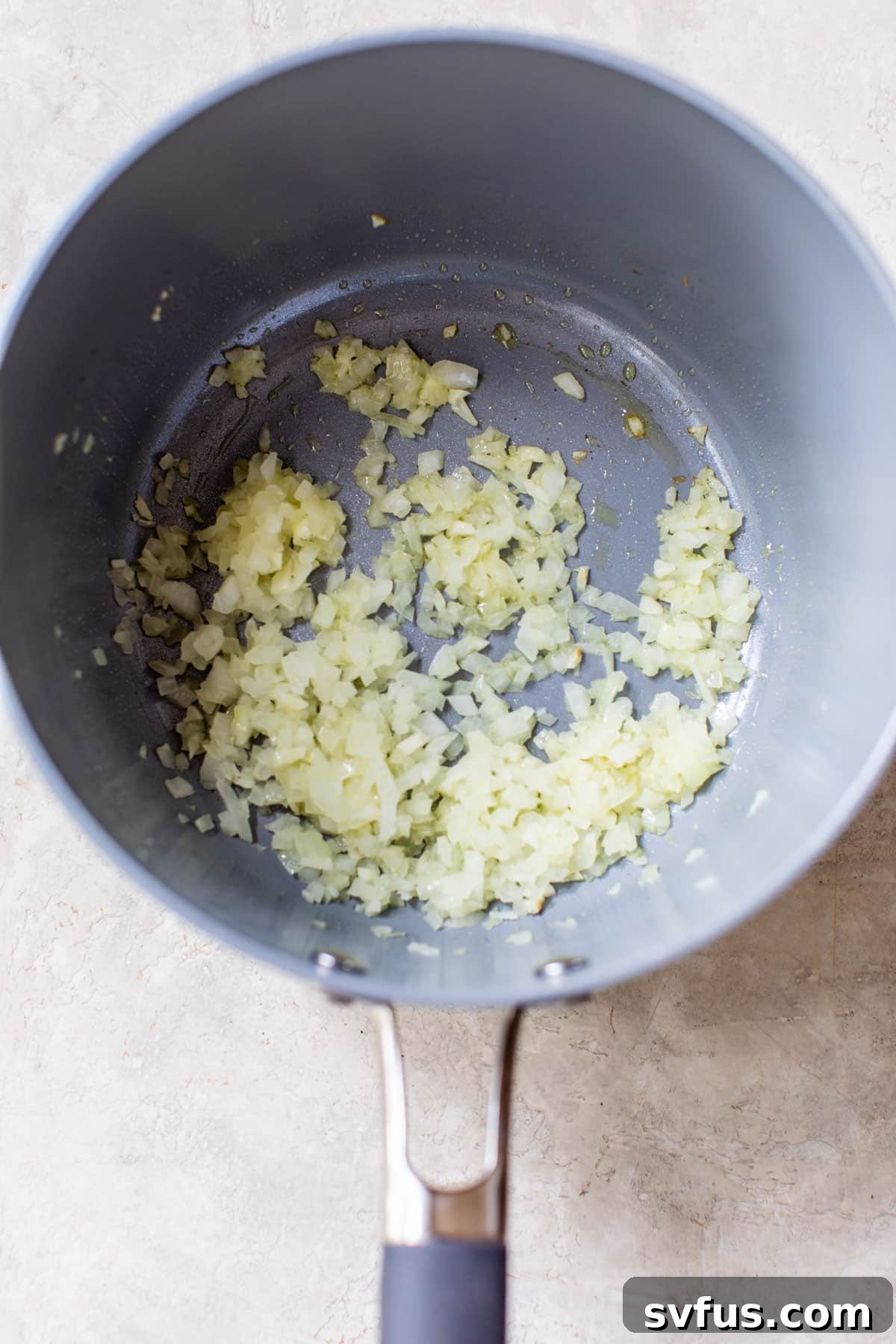 Diced onions and minced garlic gently sizzling in olive oil in a saucepan.