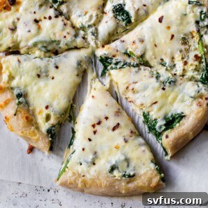 spinach and cheese pizza on parchment paper