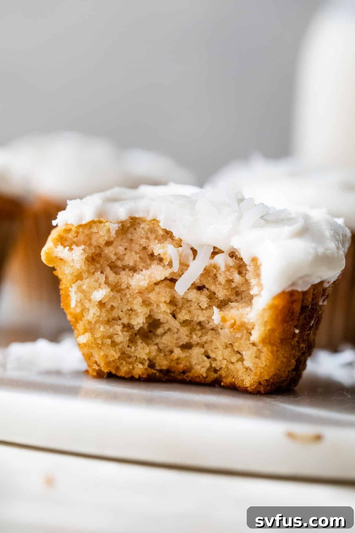 cupcake with white frosting with a bite taken out of it