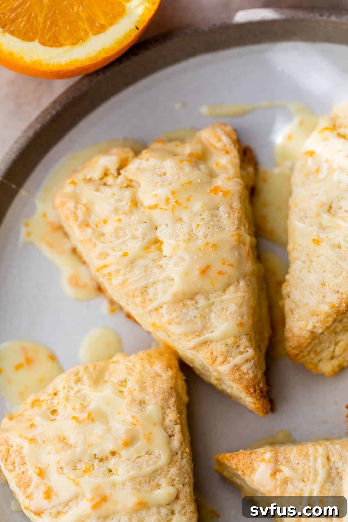 Golden orange scone topped with a sweet orange glaze and fresh orange zest, ready to be enjoyed.