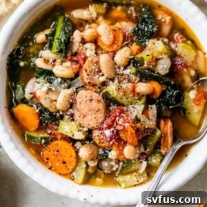 A bowl of chicken sausage soup with beans, sausage, and kale, ready to be enjoyed.