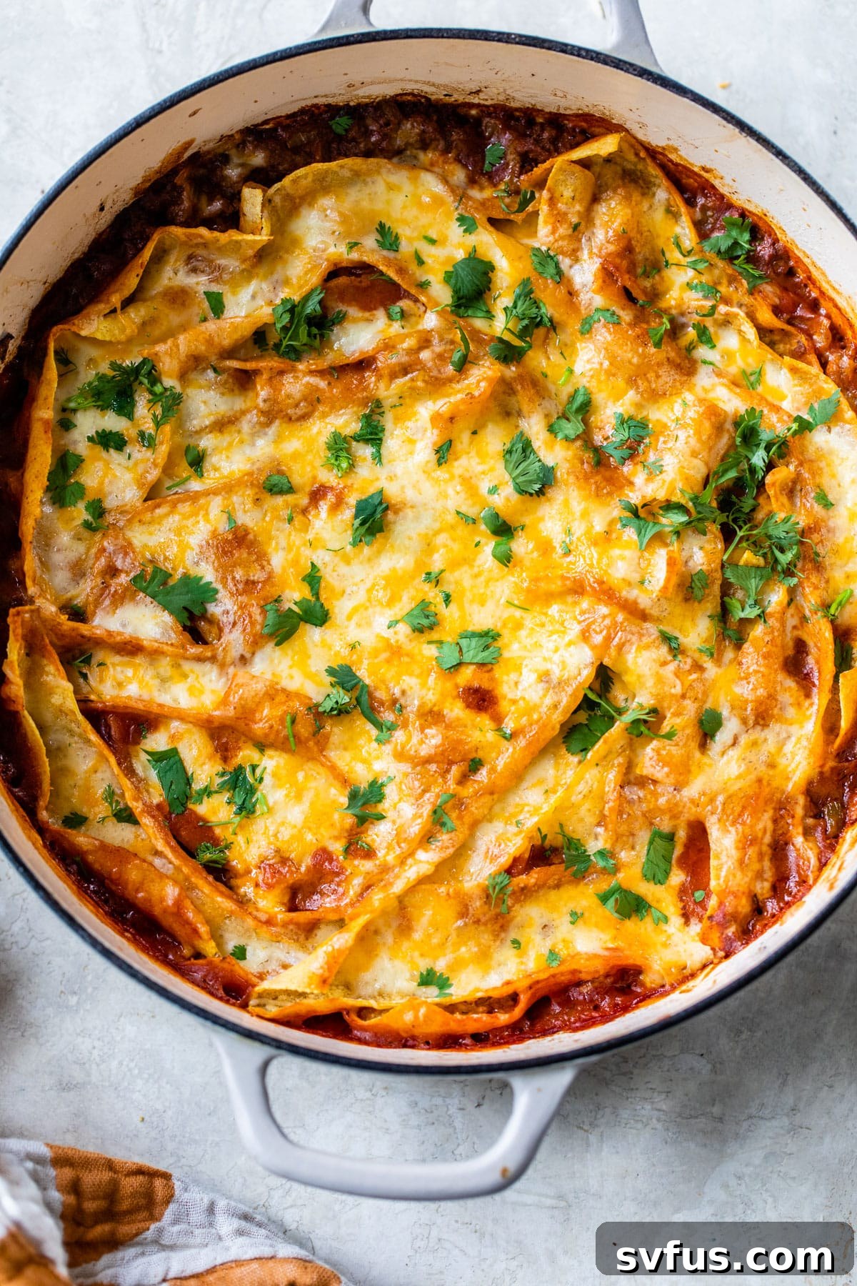 skillet topped with tortilla strips, enchilada sauce and melted cheese