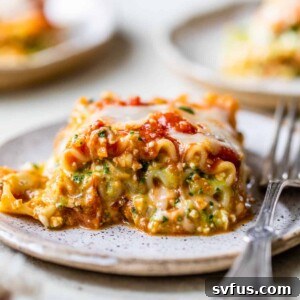 A piece of lasagna with cottage cheese on a plate with a fork