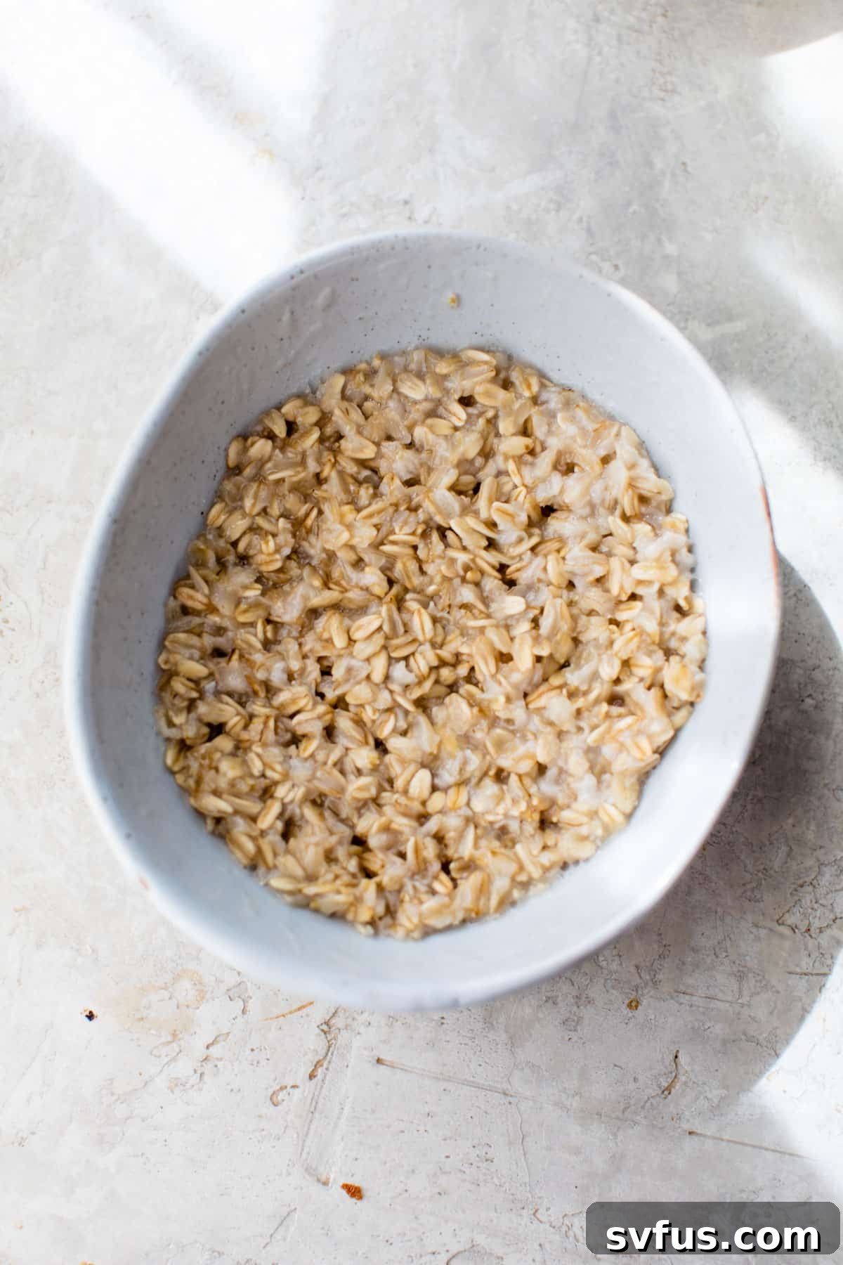 cooked oatmeal in a small bowl, ready for toppings