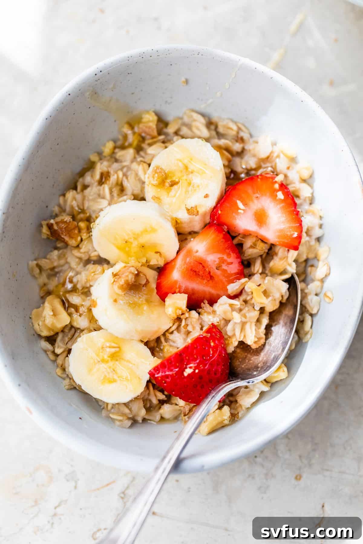 cooked oatmeal with fresh strawberries and sliced banana on top