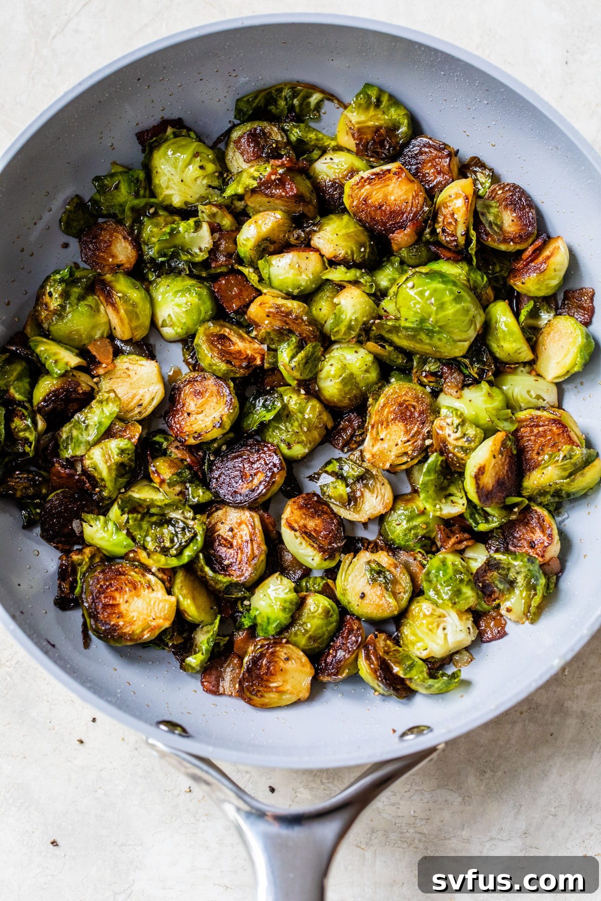 Pan-fried Brussels sprouts sizzling in a cast iron skillet with golden-brown edges