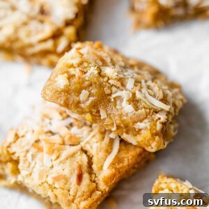 buttery bars with coconut on parchment paper