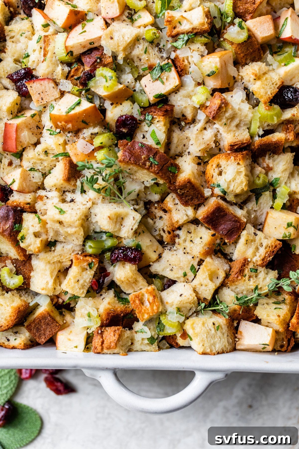 casserole dish with apples, celery, dried cranberries, and gluten-free bread cubes, pre-baking