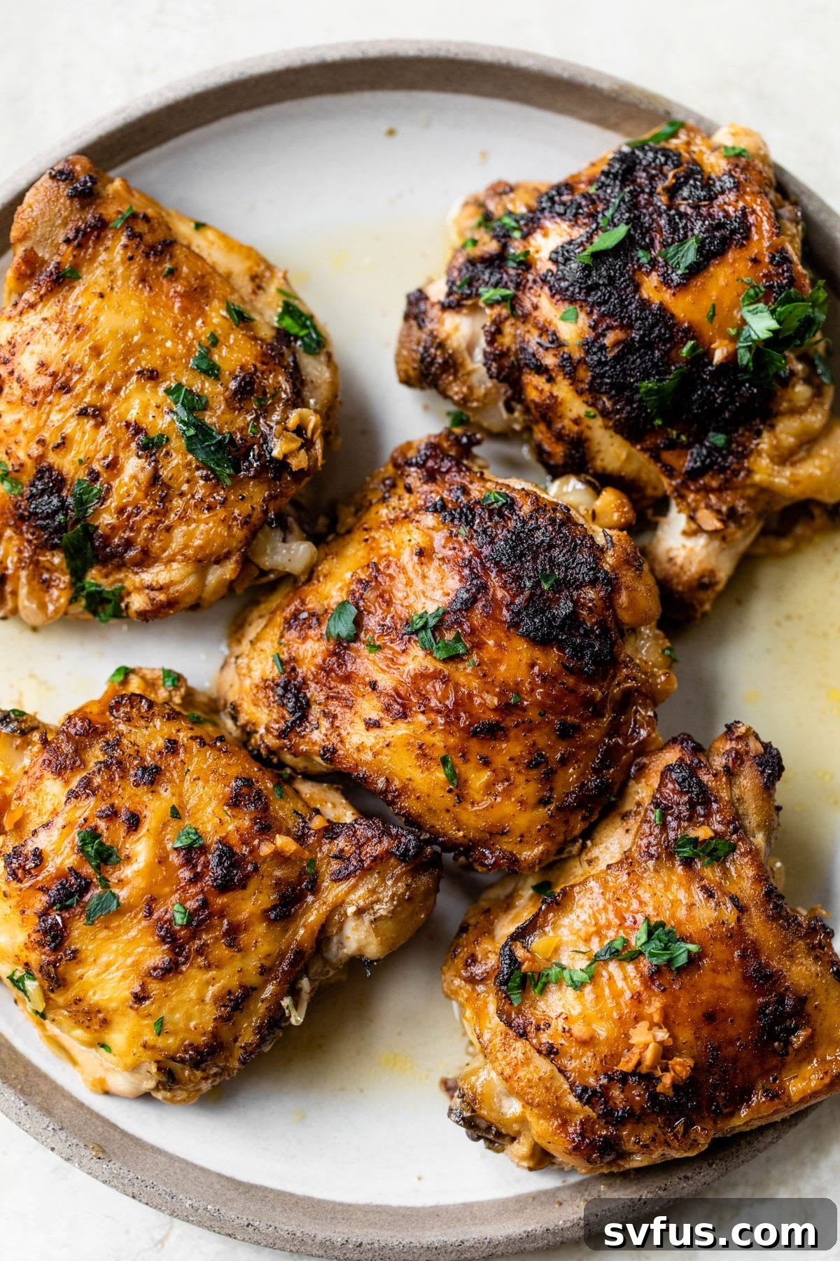 five cooked chicken thighs on a plate