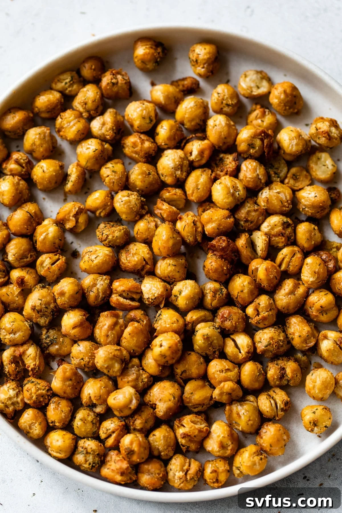 A plate of perfectly crispy, seasoned air fryer chickpeas, ready to be enjoyed as a snack or salad topper.