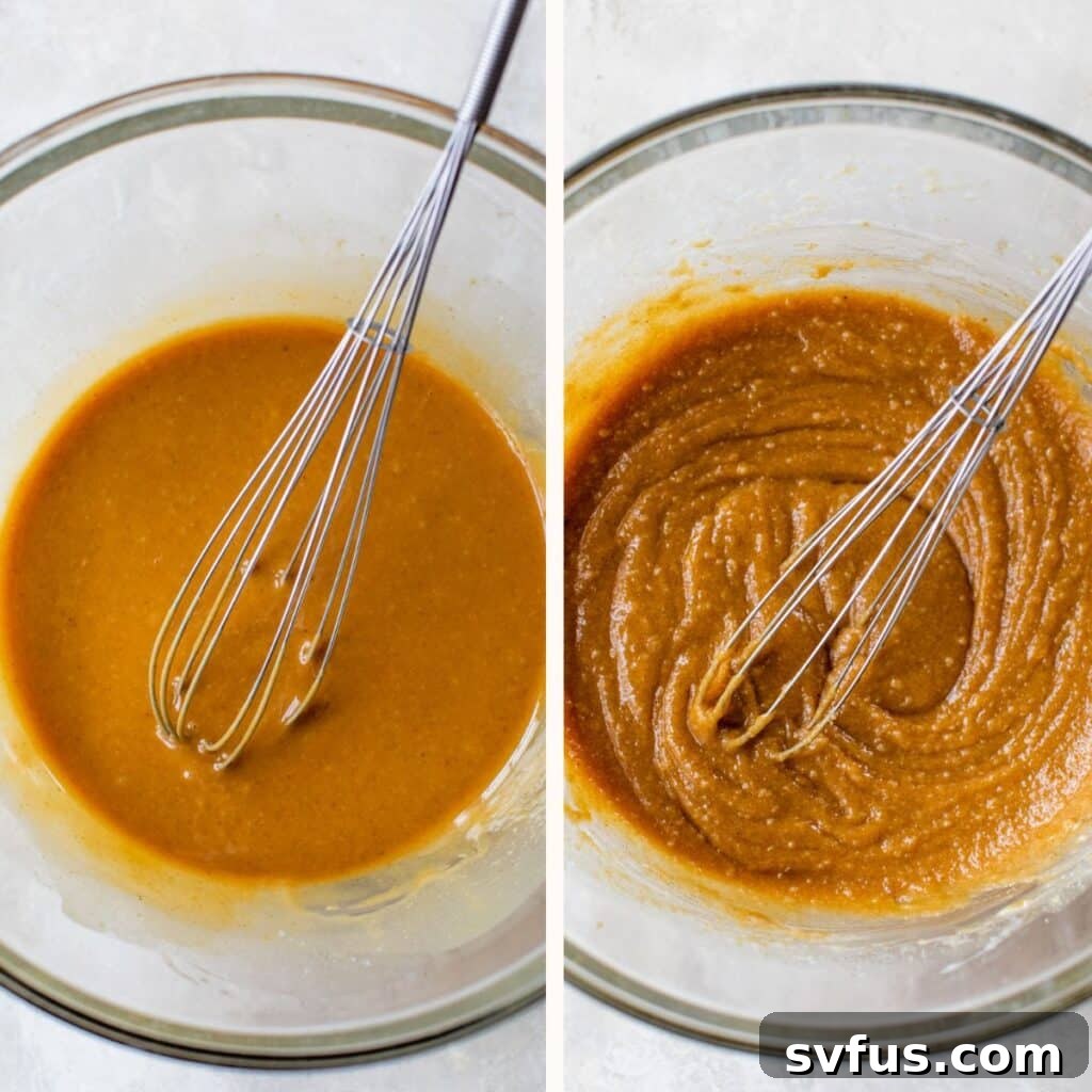 Close-up of creamy peanut butter and melted vegan butter being whisked together in a large glass mixing bowl.