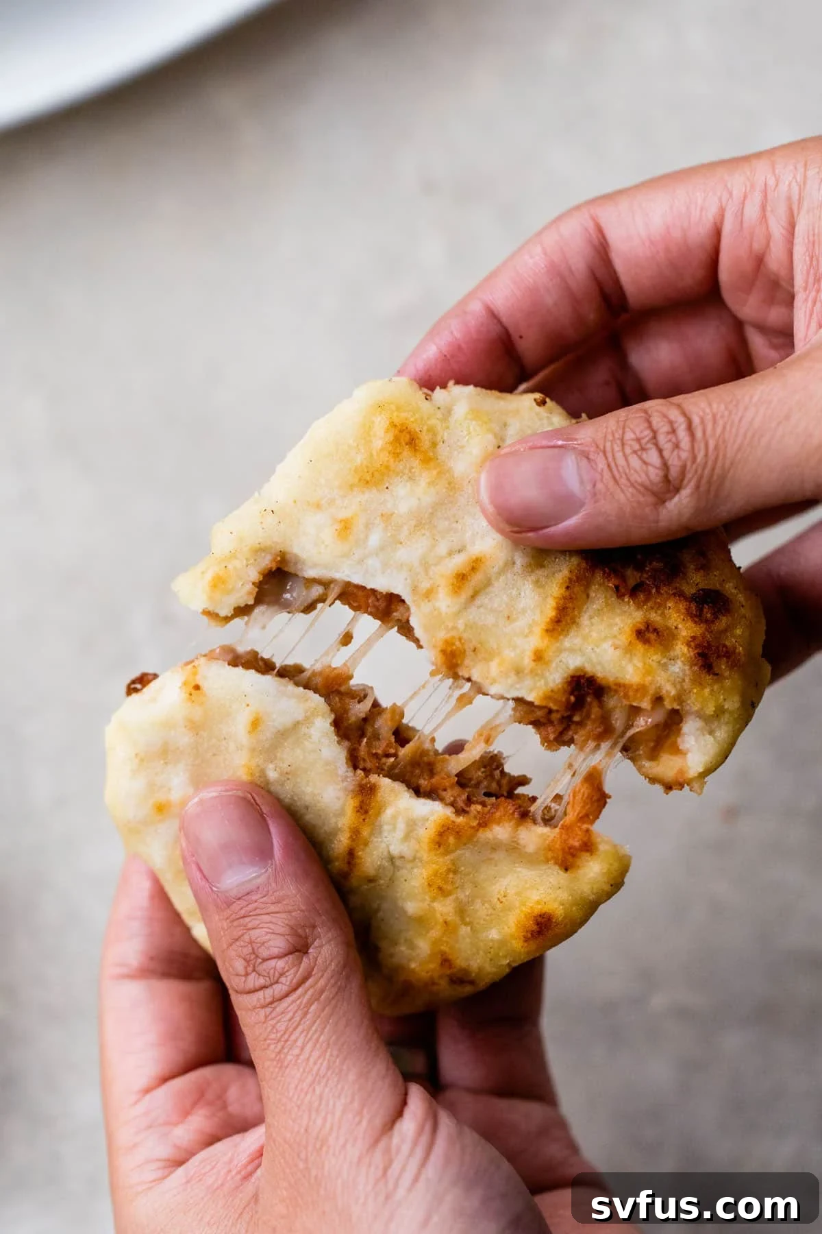 someone pulling apart dough filled with melted cheese