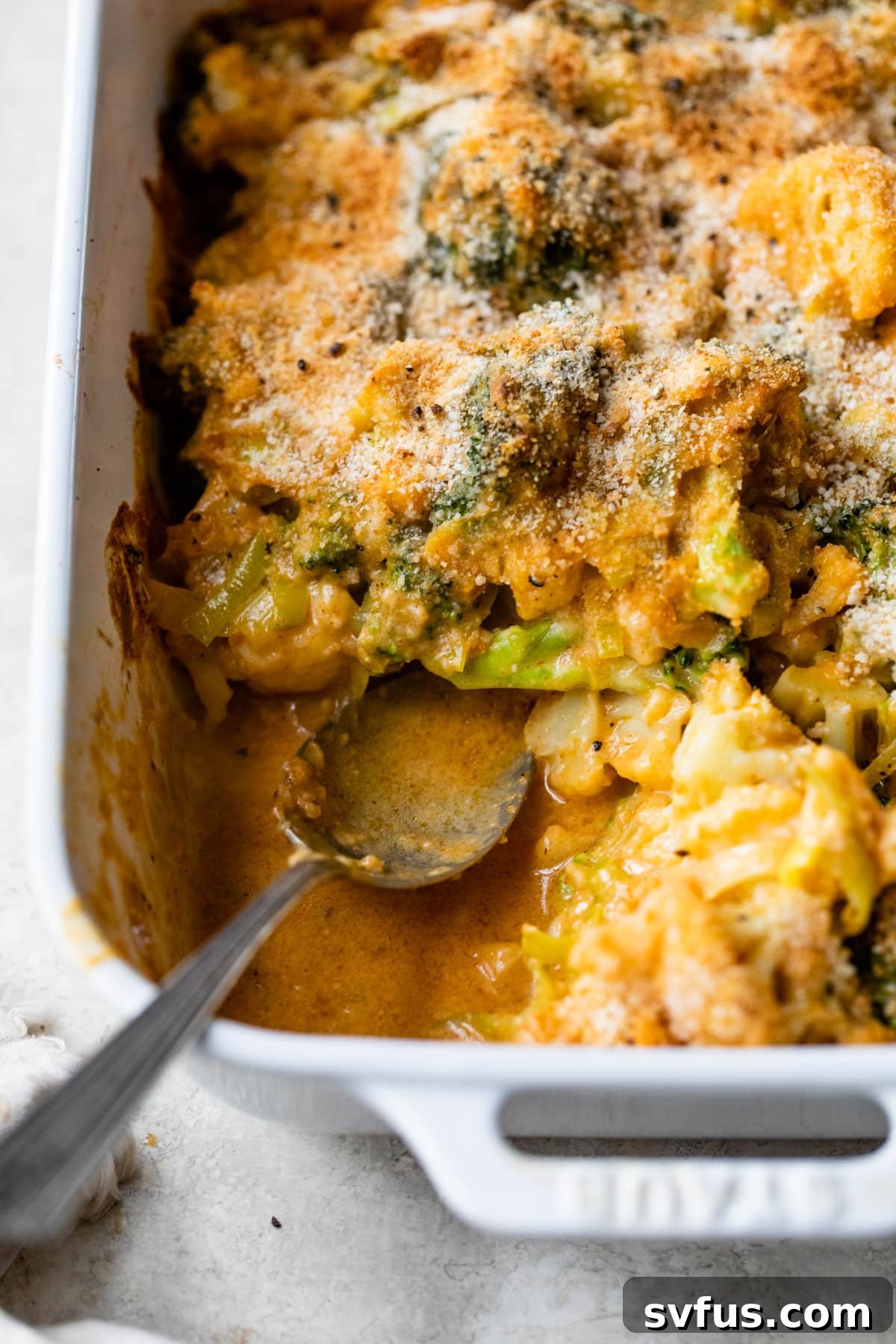 A close-up view of the cooked broccoli and cauliflower casserole, topped with golden, crispy breadcrumbs.