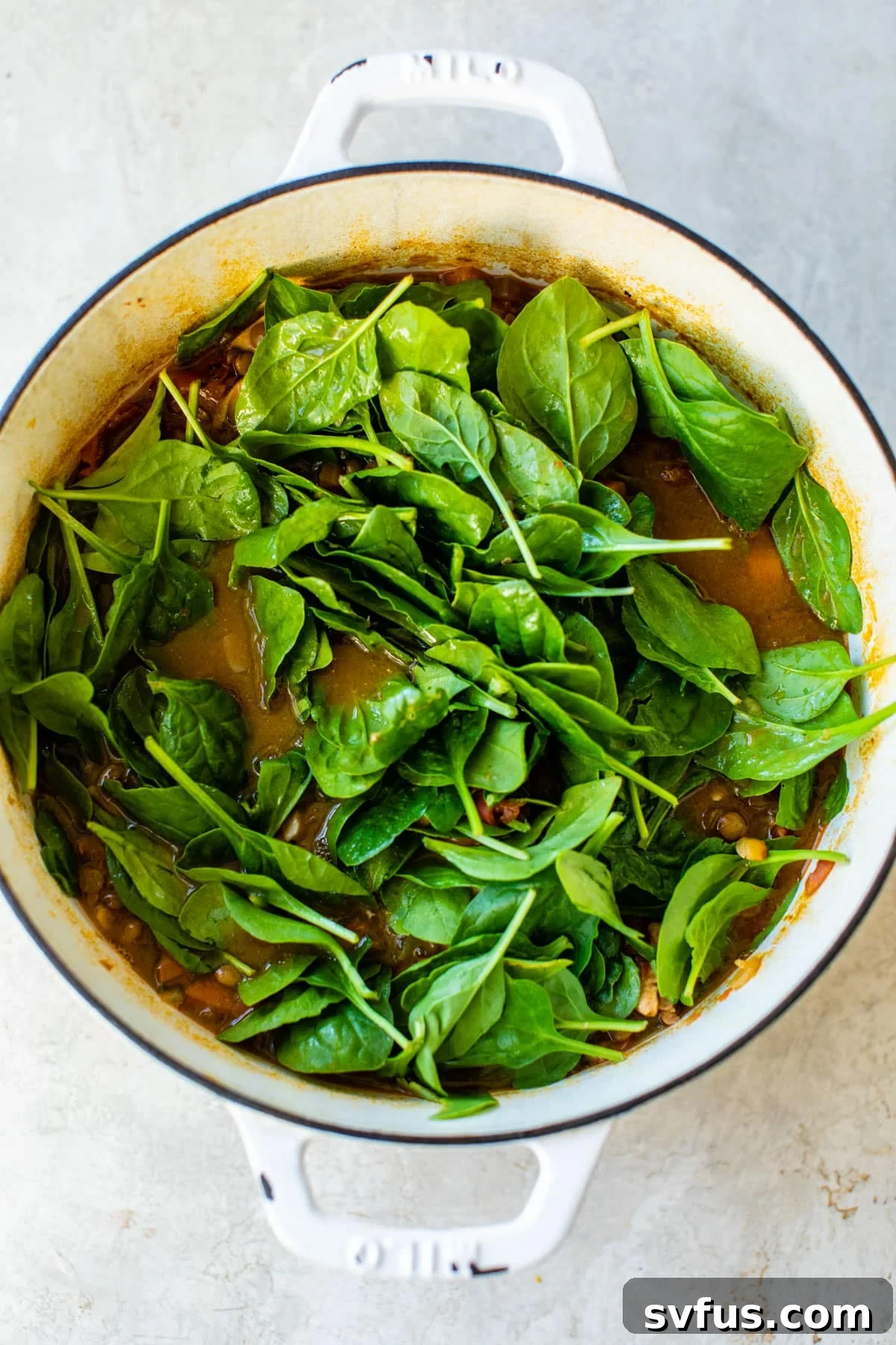 dutch oven with soup and spinach