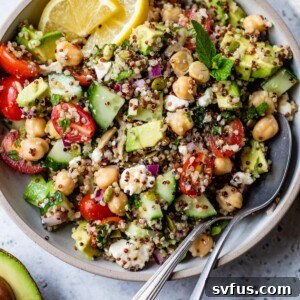 A bowl of Zesty Quinoa Salad with a spoon, ready to be served, showcasing its vibrant colors and fresh ingredients.
