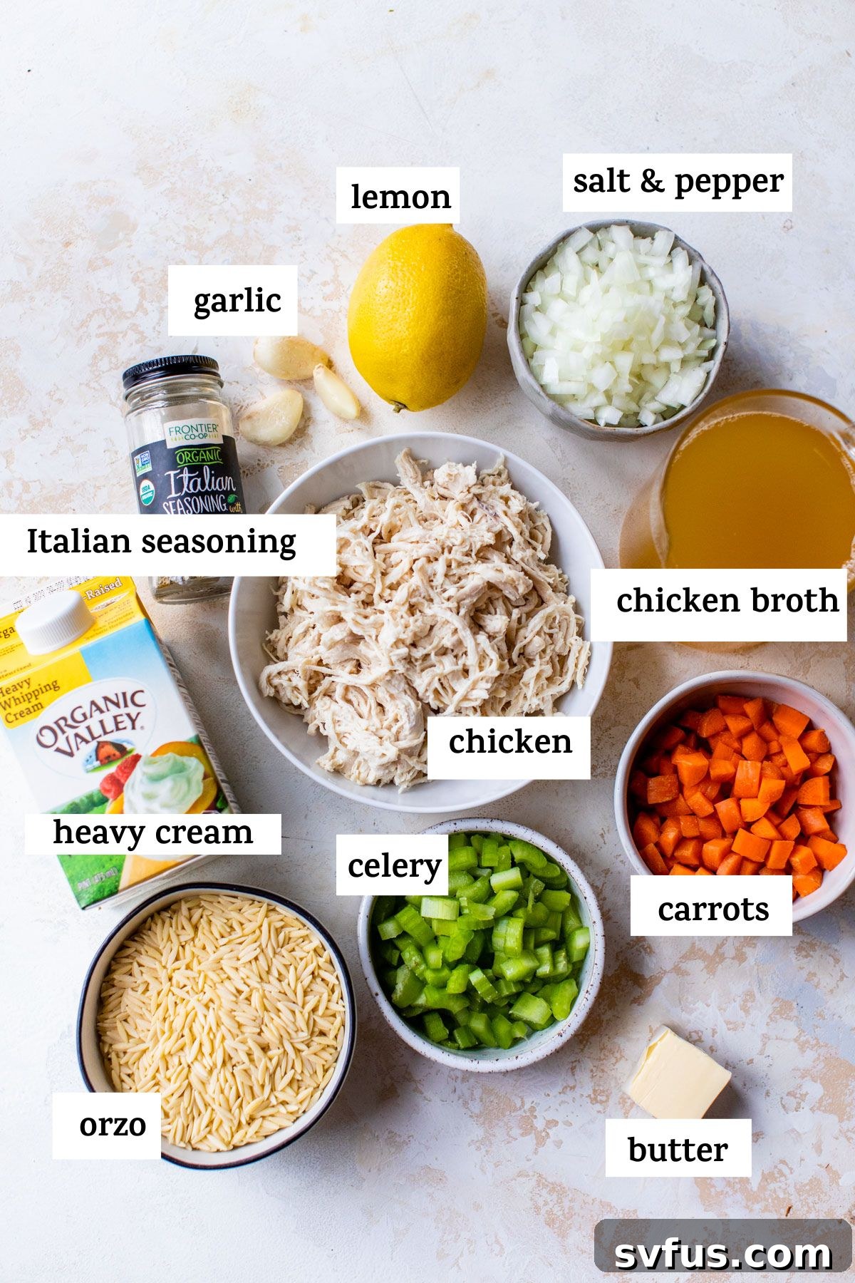 Arrangement of fresh ingredients for chicken orzo soup, including uncooked orzo pasta, shredded chicken breast, and a container of rich chicken broth.