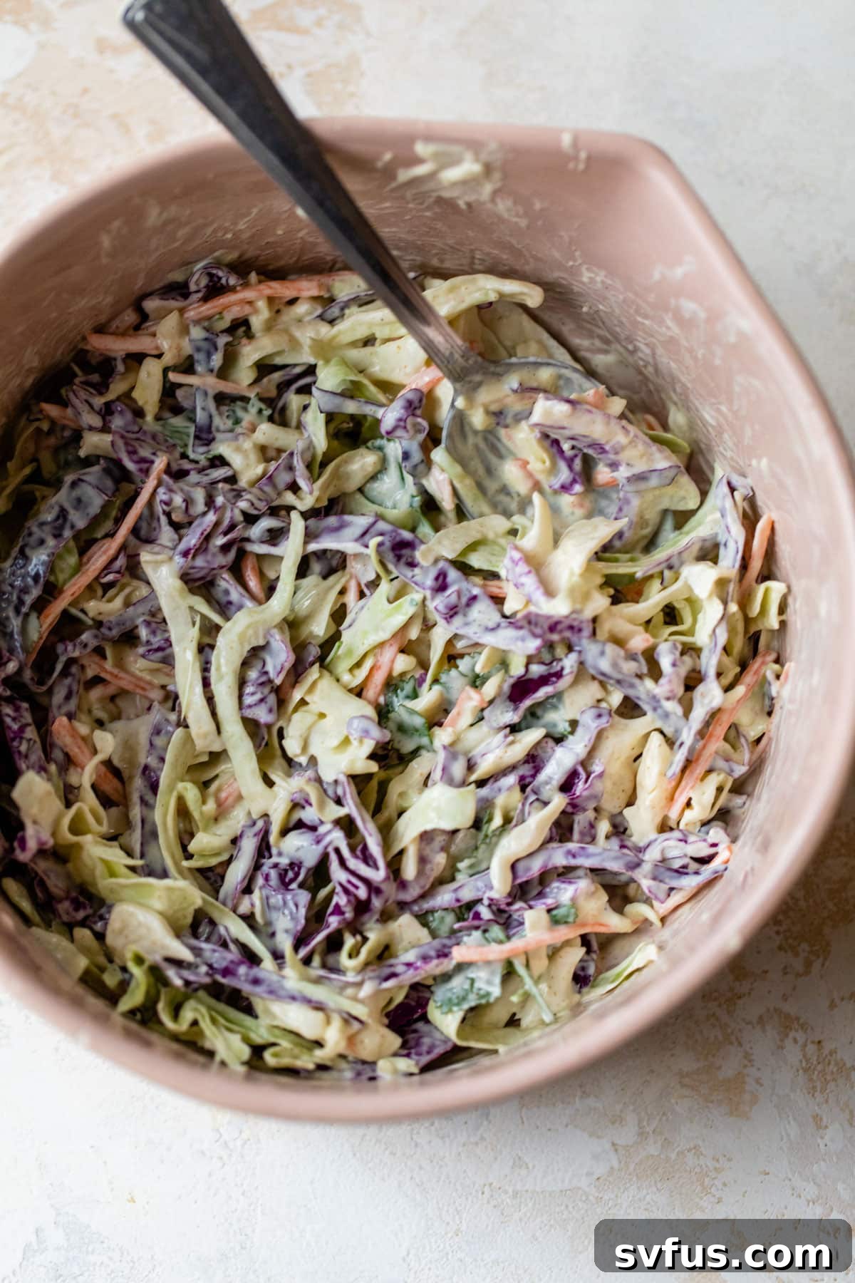 Vibrant cilantro-lime cabbage slaw in a large mixing bowl, ready to top rotisserie chicken tacos