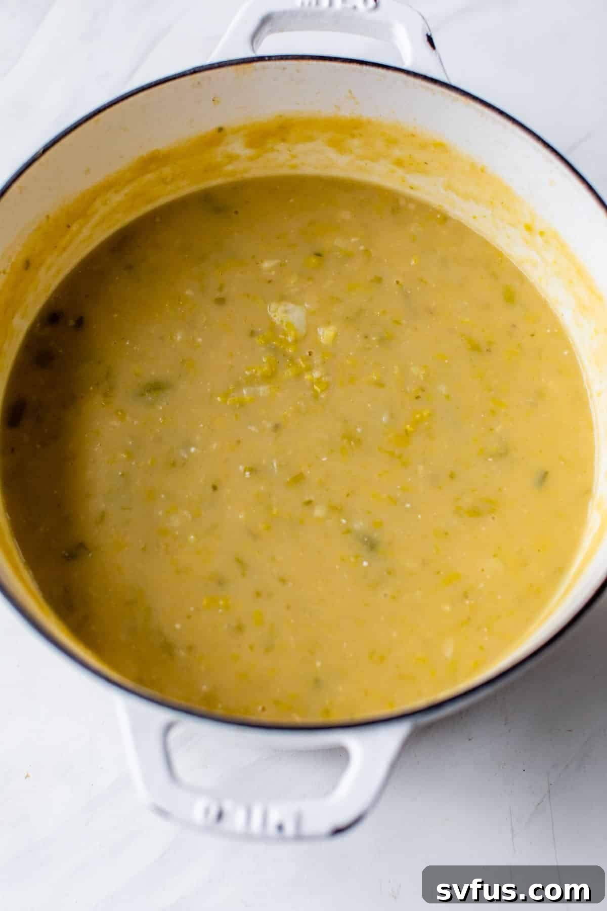 A smooth, blended portion of vegan potato leek soup in a Dutch oven, showcasing its creamy texture.