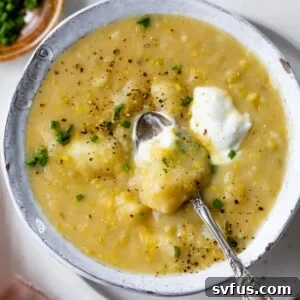 A bowl of creamy vegan potato leek soup, garnished and ready to eat.