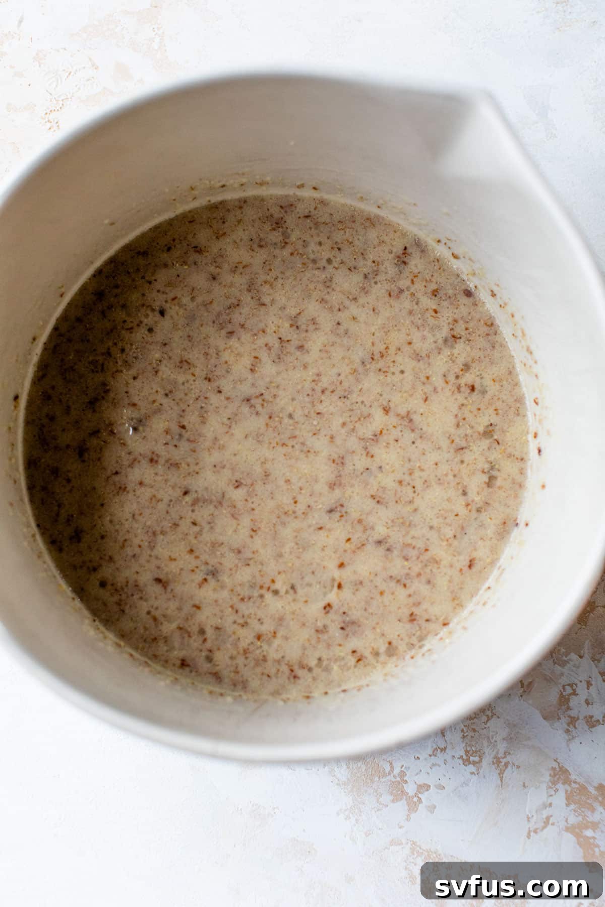 A small bowl containing a mixture of ground flaxseed and water, showcasing the process of making a flax egg.