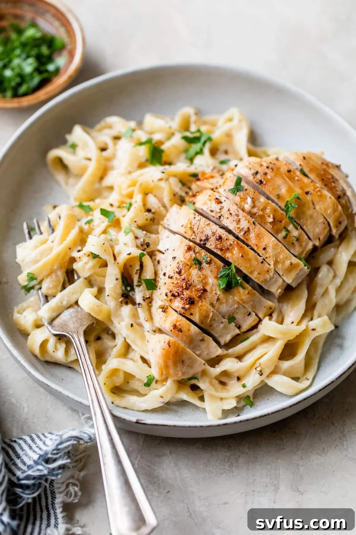 a plate of fettuccine and chicken alfredo on a plate with a fork
