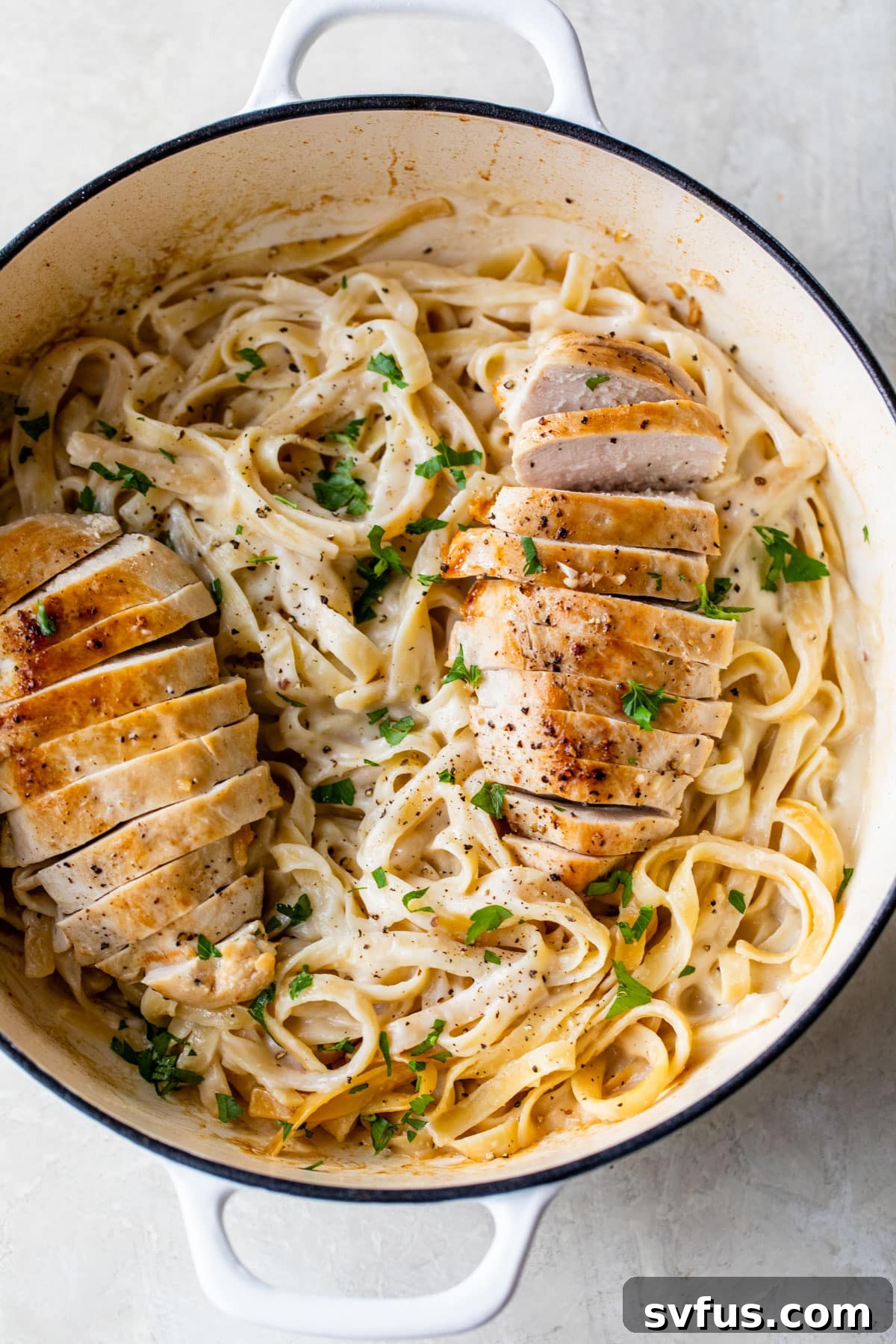 a dutch oven with fettuccine and chicken alfredo inside