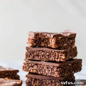 A stack of 4 chocolate bars on a table with a bite taken out of the top one