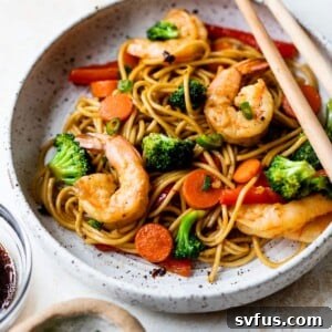 shrimp lo mein in a bowl with chopsticks
