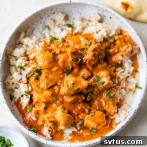 a bowl of butter chicken overtop rice in a bowl