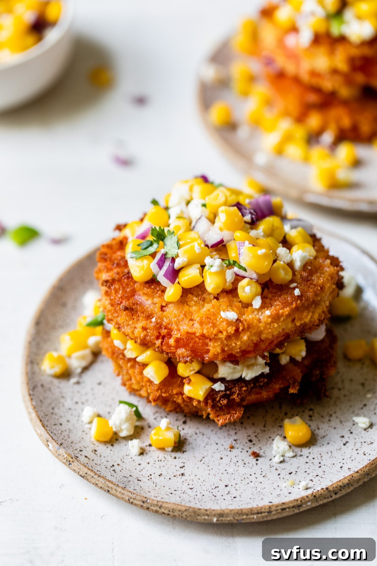 Stacked crispy fried tomatoes topped with vibrant corn salsa, ready to be enjoyed as an appetizer or a summer side dish.