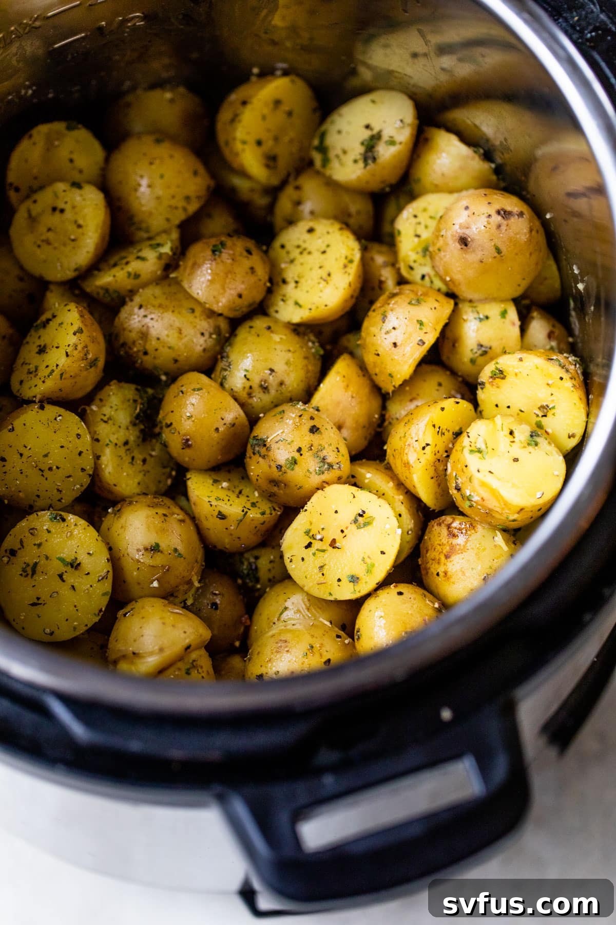 A bowl of freshly made Instant Pot Potatoes, garnished with vibrant green herbs and a rich, buttery sheen.