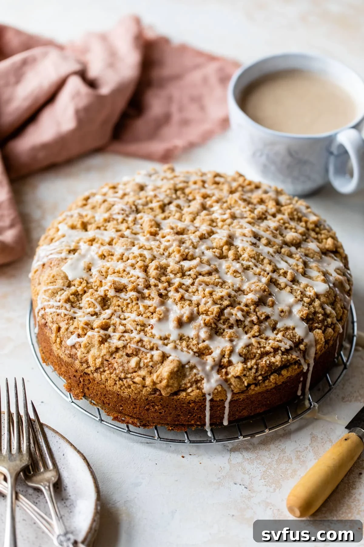 an overview of a whole vegan coffee cake with vanilla icing drizzled on top