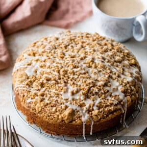 an overview of a whole vegan coffee cake with vanilla icing drizzled on top