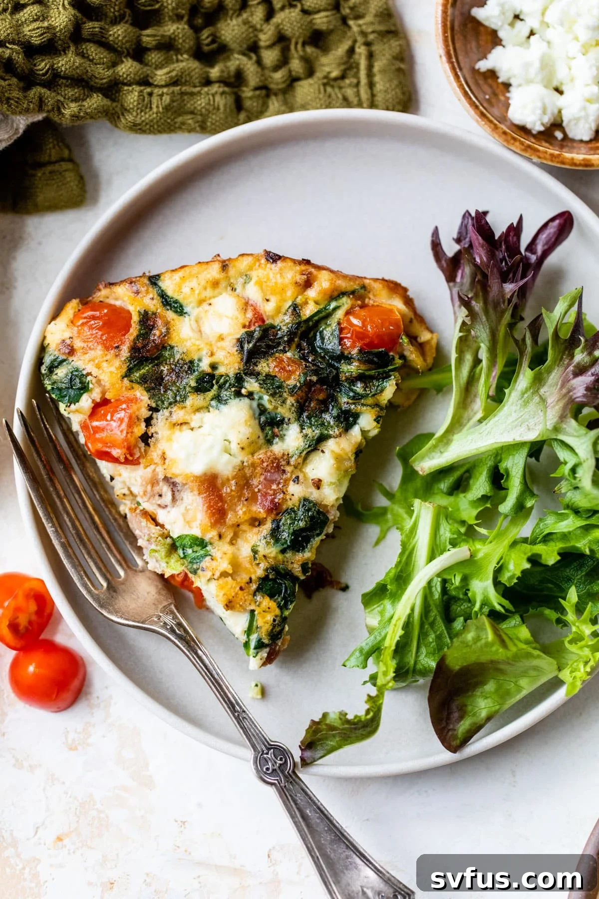 A perfectly cooked slice of egg white frittata on a plate with a fork, ready to be enjoyed.