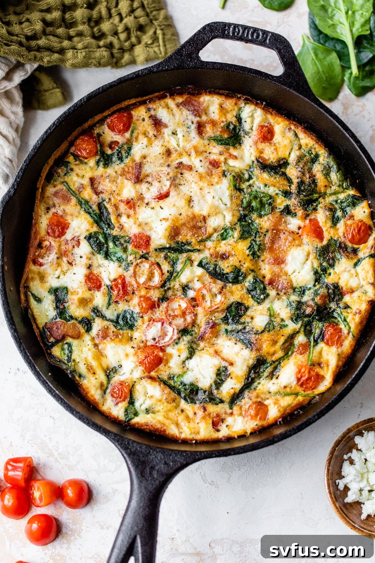 A freshly baked egg white frittata in a cast iron skillet, golden brown and perfectly set.